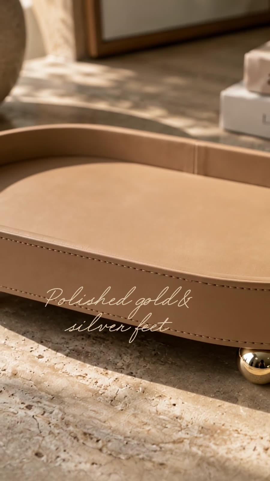 Macro frame — tan leather oval tray on polished gold ball feet